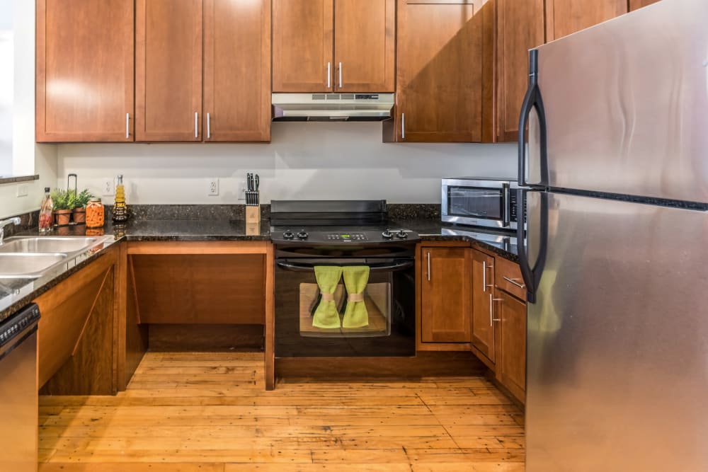 Kitchen with black appliances and ample cabinet storage at The Gallery Lofts in Winston Salem, North Carolina