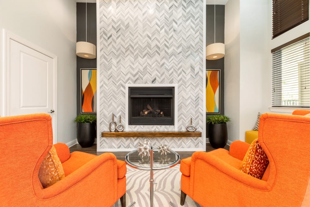 Common lounge area with seating and fireplace at Art Avenue Apartment Homes in Orlando, Florida