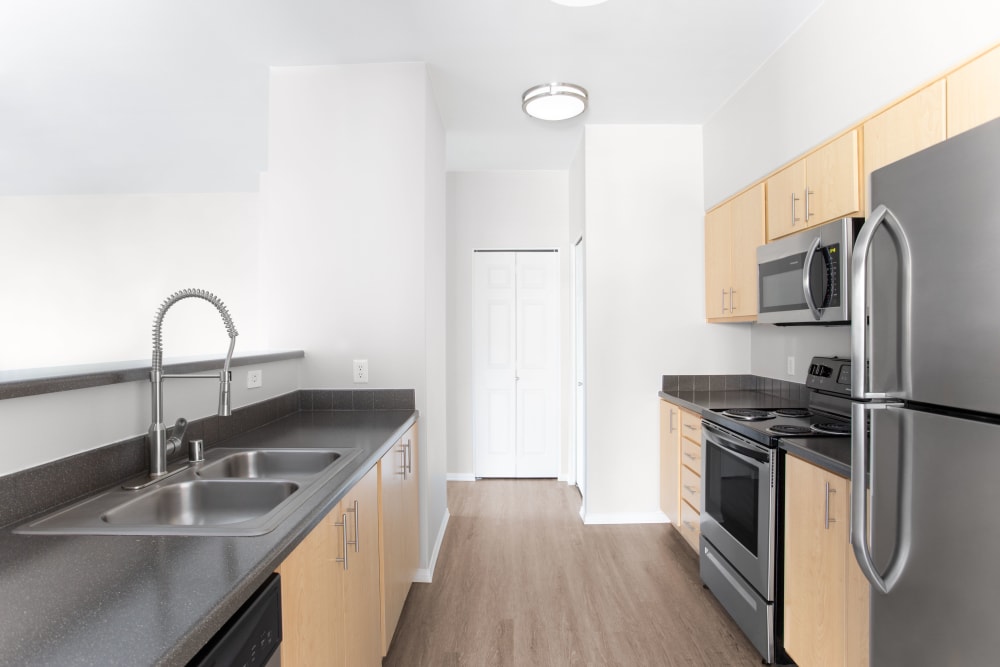 Kitchen with modern appliances at River Trail Apartments in Puyallup, Washington