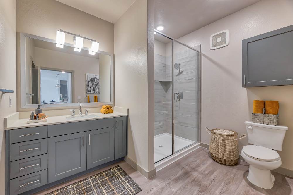 Bathroom with a large mirror and lights at Ennova Highlands in Arlington, Texas