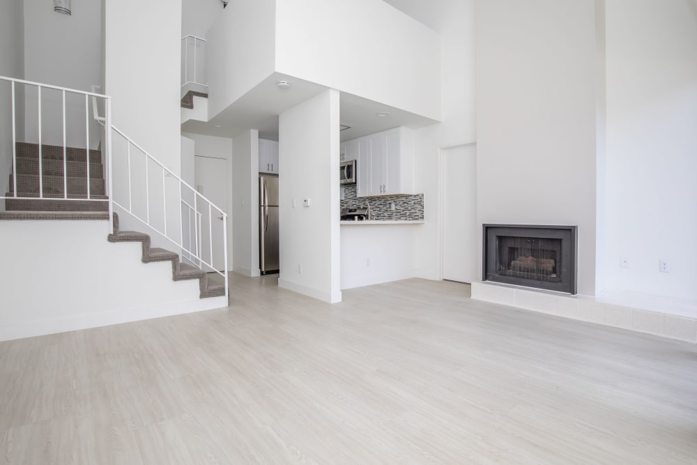 Living room with fireplace and stairs to the loft at Club Marina Apartments in Los Angeles, California