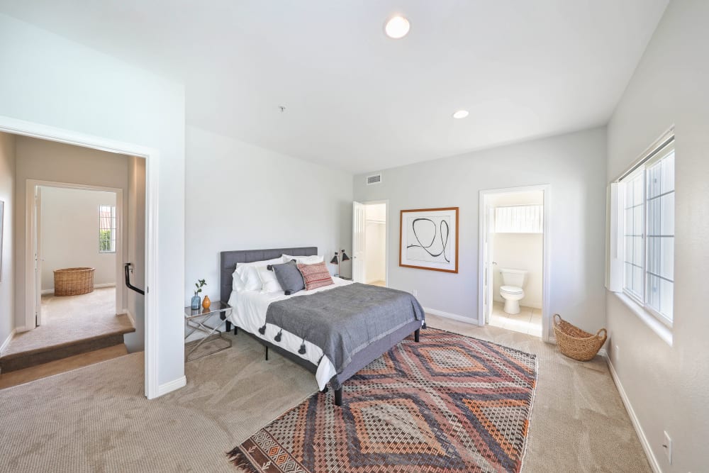 A bright, furnished bedroom at Pacific Breeze Townhomes in Huntington Beach, California