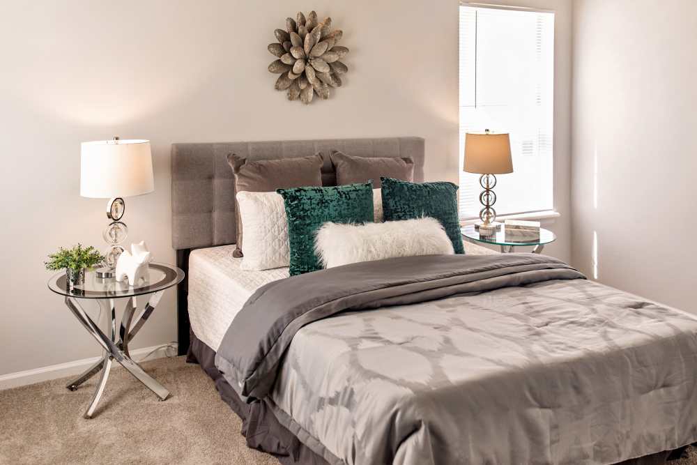 Bedroom with side lamp and window at Bonhomme Village in Olivette. MO