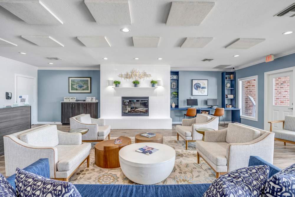 Bright lounge with cozy seating, modern fireplace, and stylish decor, ideal for relaxing or working at Carlton Arms Of Winter Haven in Winter Haven, Florida