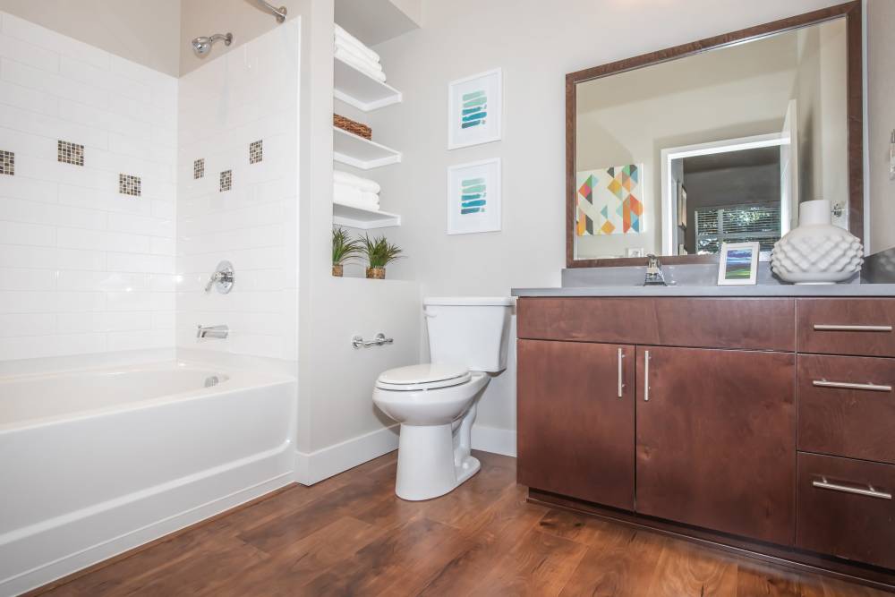 Bright bathroom with sink, commode and bathtub at Park Place Olde Town Apartments in Arvada, Colorado
