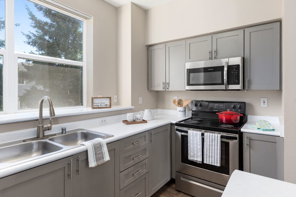 Kitchen with gray cabinetry at HighGrove Apartments in Everett, Washington