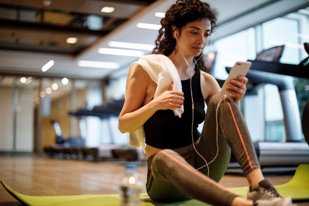 A woman in the fitness center at The Woodlands Apartments in Sacramento, California