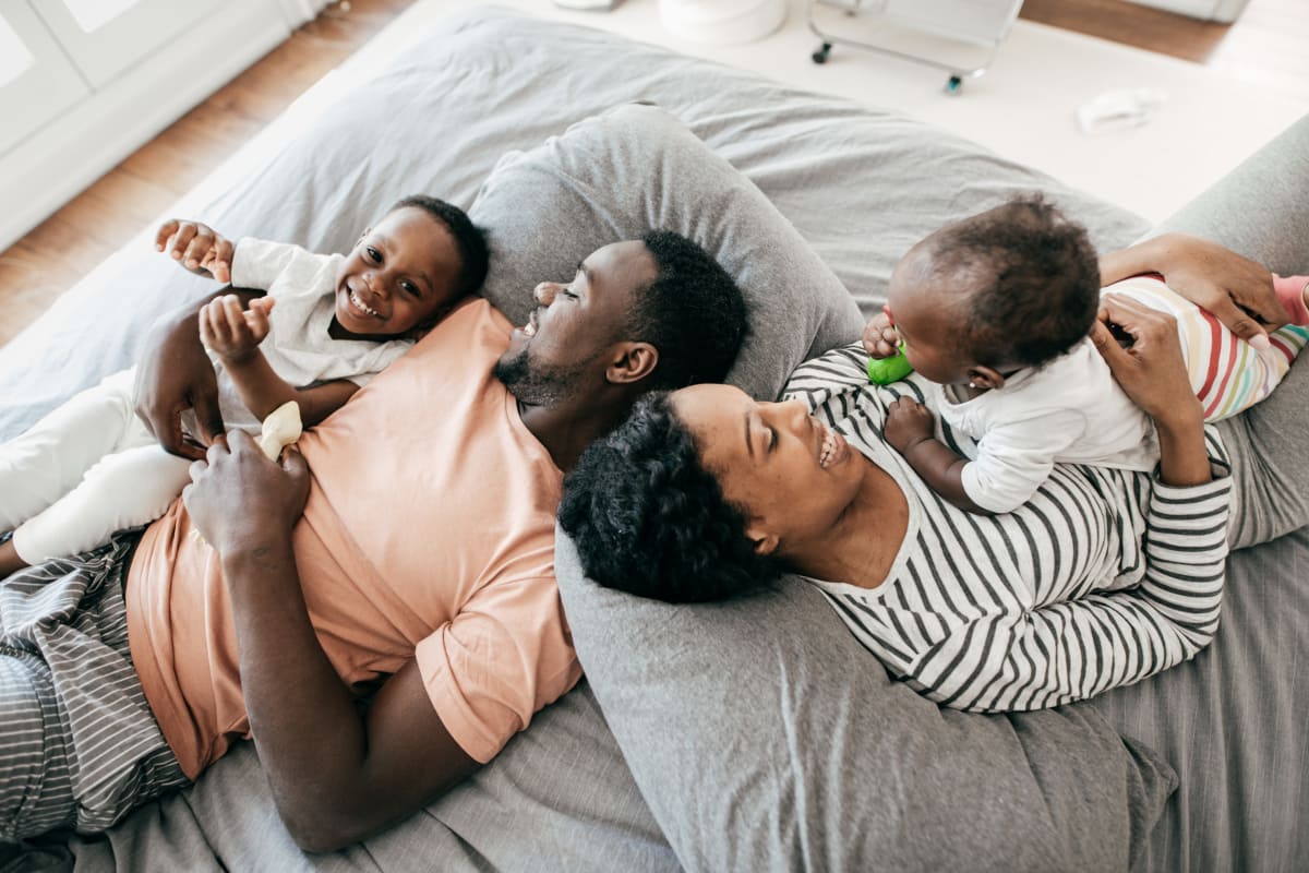 Residents laying in bed with their children in their beautiful apartment style home at West Fifth Apartments in Ontario, California