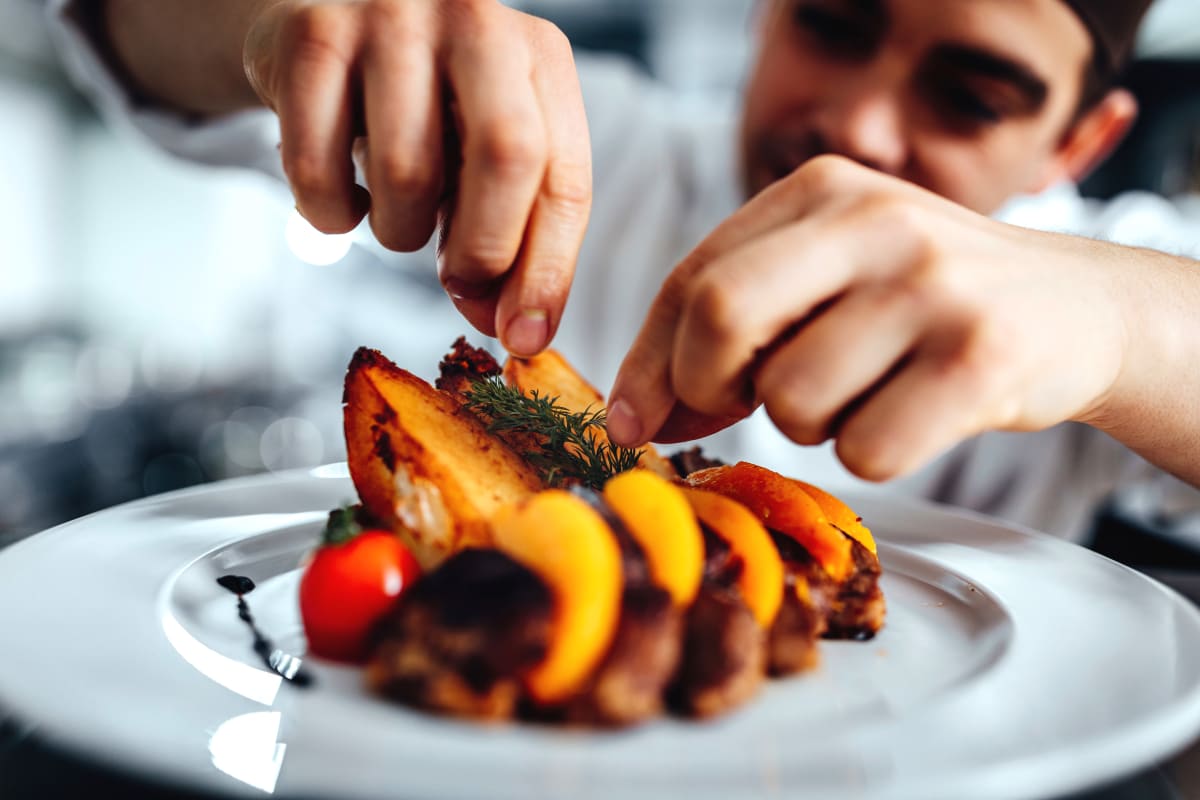 A chef plating food at Claiborne Senior Living.