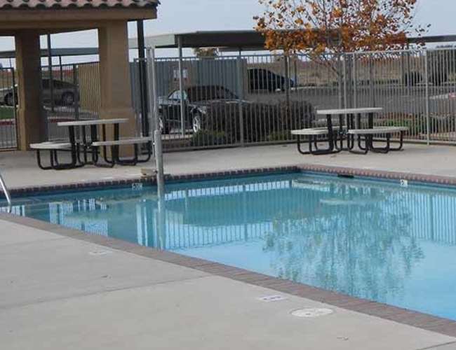 Swimming pool area with resident seating space at Villa Escondido in Orange Cove, California