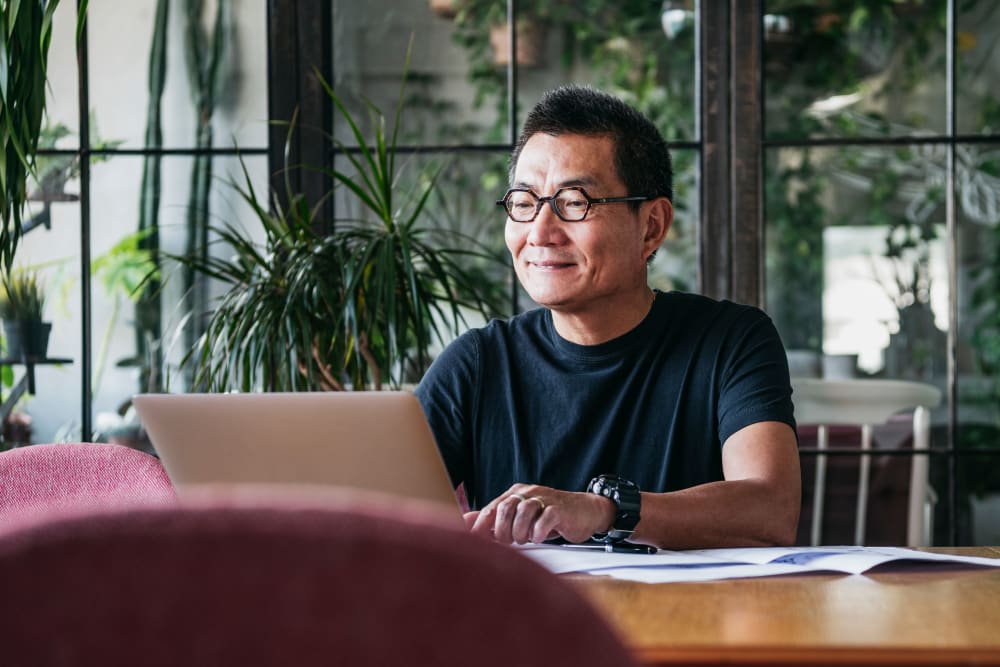 A resident on his laptop at Carriage Park Apartments in Vancouver, Washington