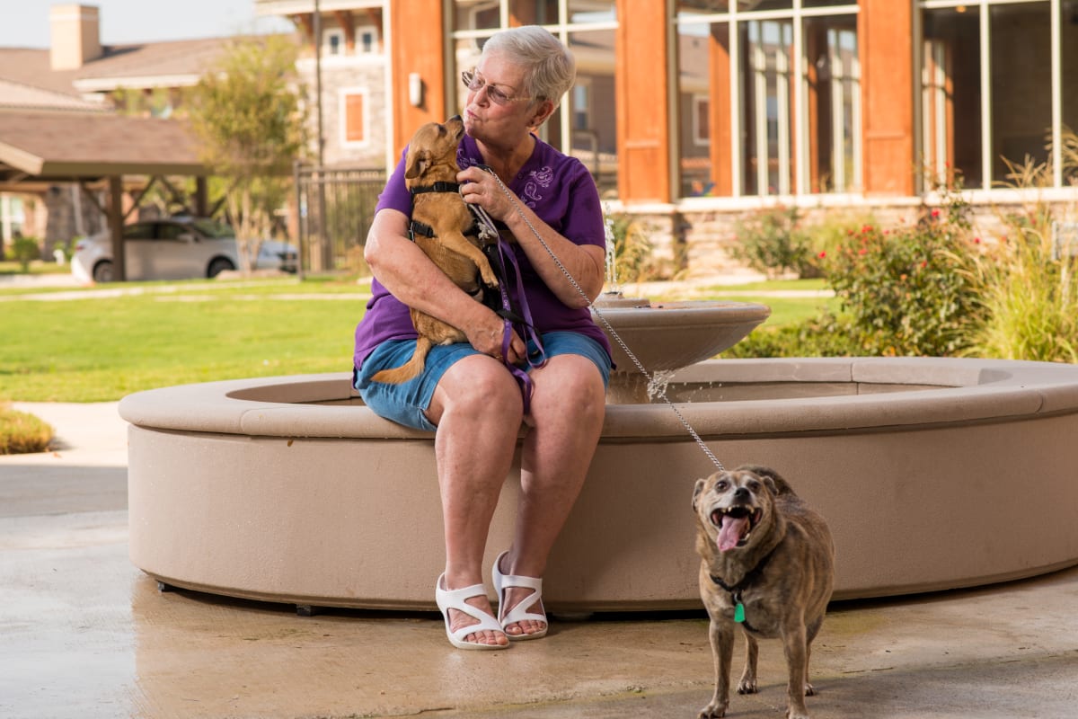 Resident with her dogs at Isle at Raider Ranch in Lubbock, Texas