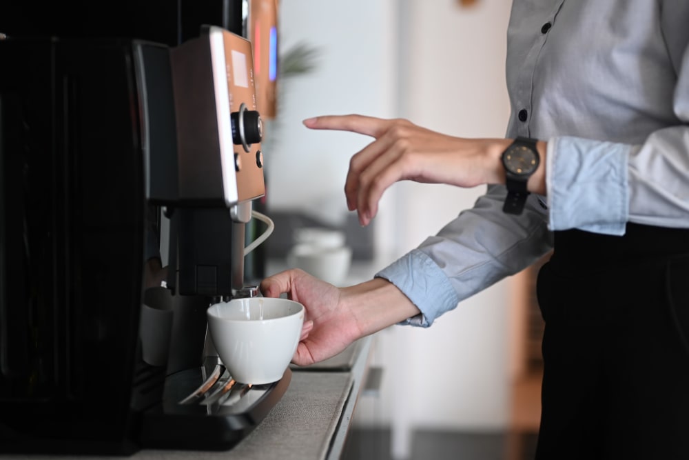 Woman pouring coffee in business center at Sorrel Phillips Creek Ranch in Frisco, Texas