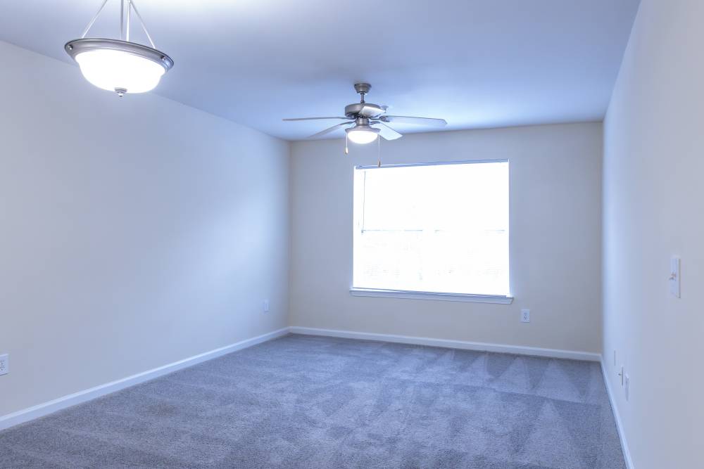 Unfurnished living room with ceiling fan and large window at Ashton Walk in Forest Park, Georgia
