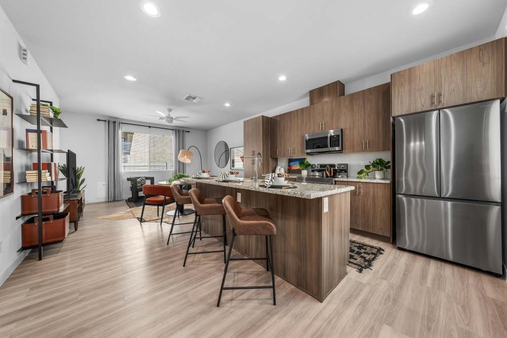 Kitchen with stainless-steell appliances and island countertop for breakfast at Obsidian at South Mountain in Phoenix, Arizona