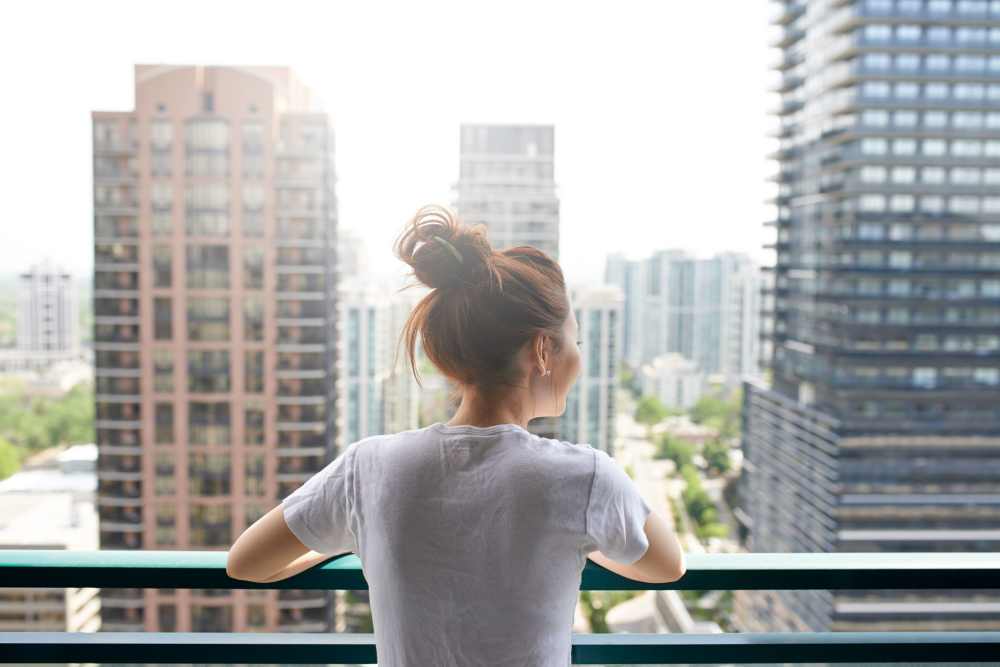 Woman looking at the view of downtown from her work building at Treybrooke Village in Greensboro, North Carolina