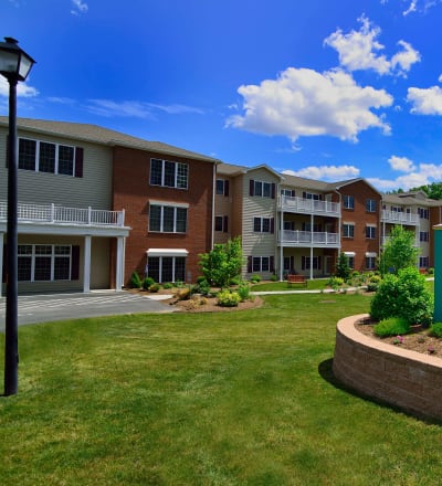 Lawn and grounds with walking paths and a pond at Keystone Commons in Ludlow, Massachusetts