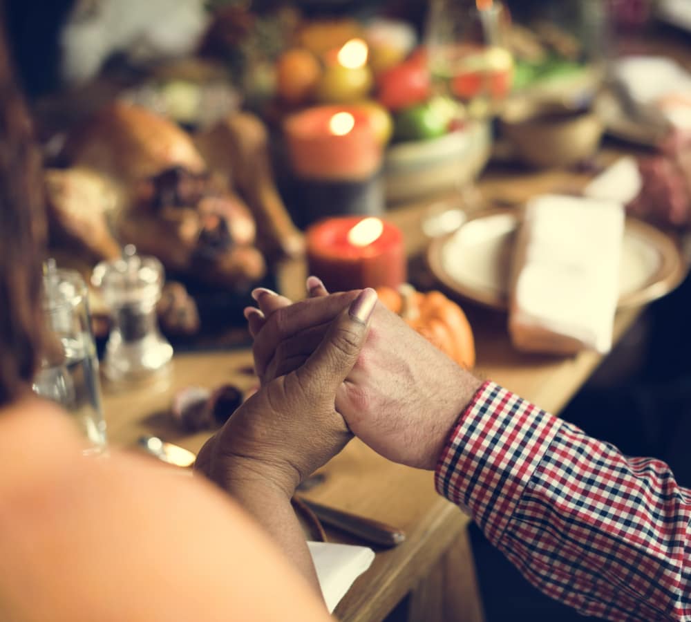 Residents Holding hands before a meal at The Creekside in Woodinville, Washington