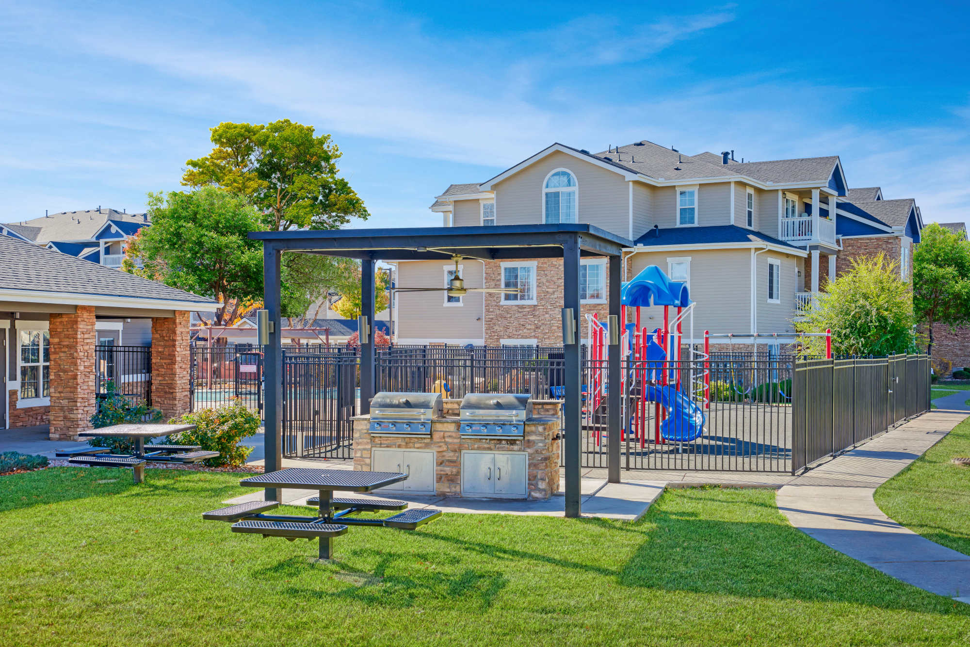 Grilling area surrounded by lush green grass at Westridge Apartments in Aurora, Colorado