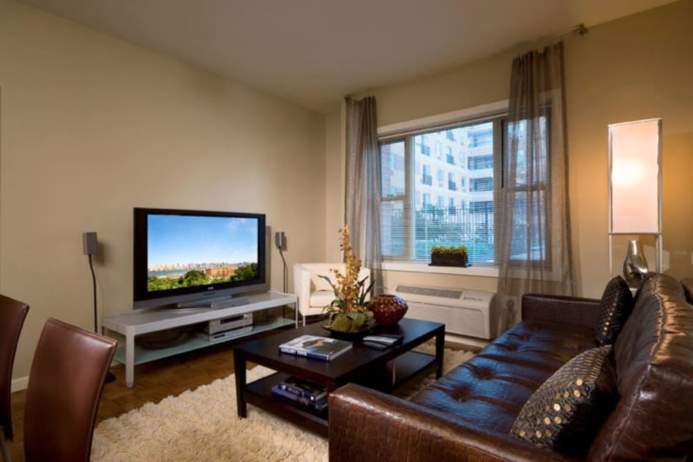 Spacious living area with poolside view at 55 Riverwalk Place in West New York, New Jersey