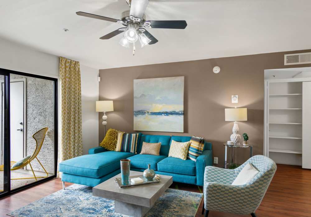 Spacious living room with large sofa and balcony access at Cabrillo Apartments in Scottsdale, Arizona, 