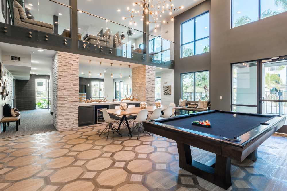 Spacious lounge with a modern kitchen, pool table, and skylights at The Walton in Sanford, Florida.