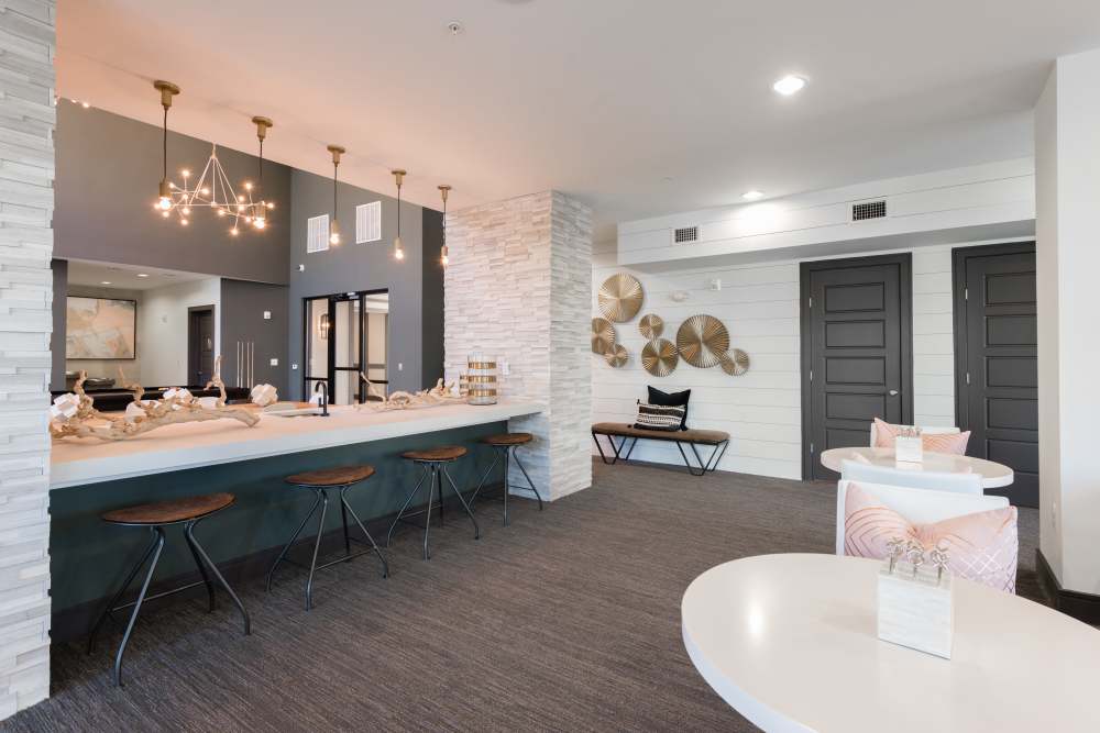 Sleek communal lounge with modern bar seating and stylish decor at The Walton in Sanford, Florida.