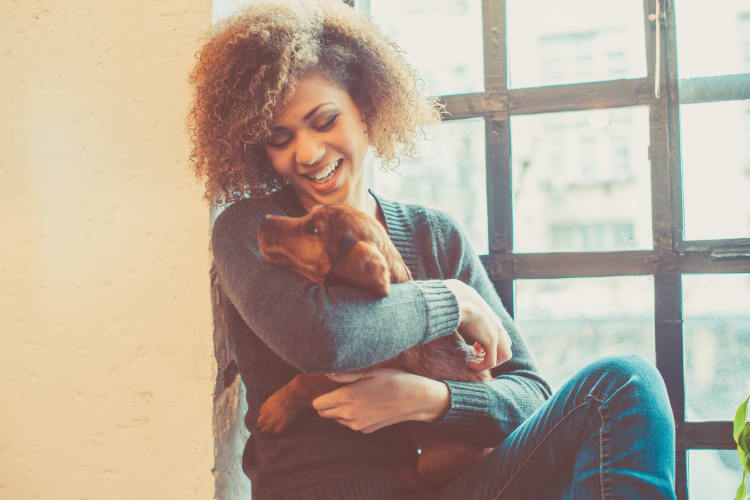 Woman resident cuddling with her dog at SUR702 in Las Vegas, Nevada