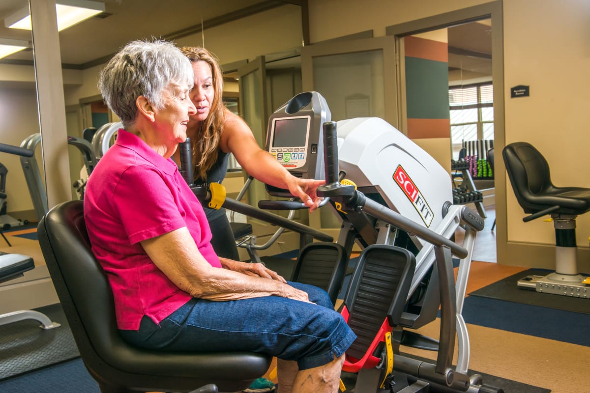 Resident learning how to use fitness equipment at an Integrated Senior Lifestyles community