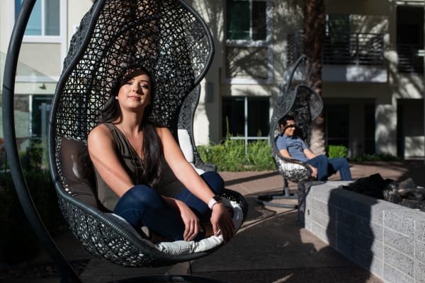 Residents relaxing in the swinging chairs near the fire pit at The Regents at Scottsdale in Scottsdale, Arizona