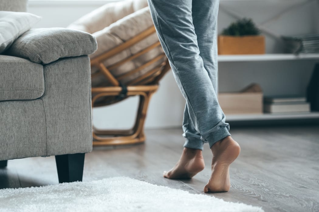 Resident walking by hardwood floor at Veridian Place home in Dallas, Texas