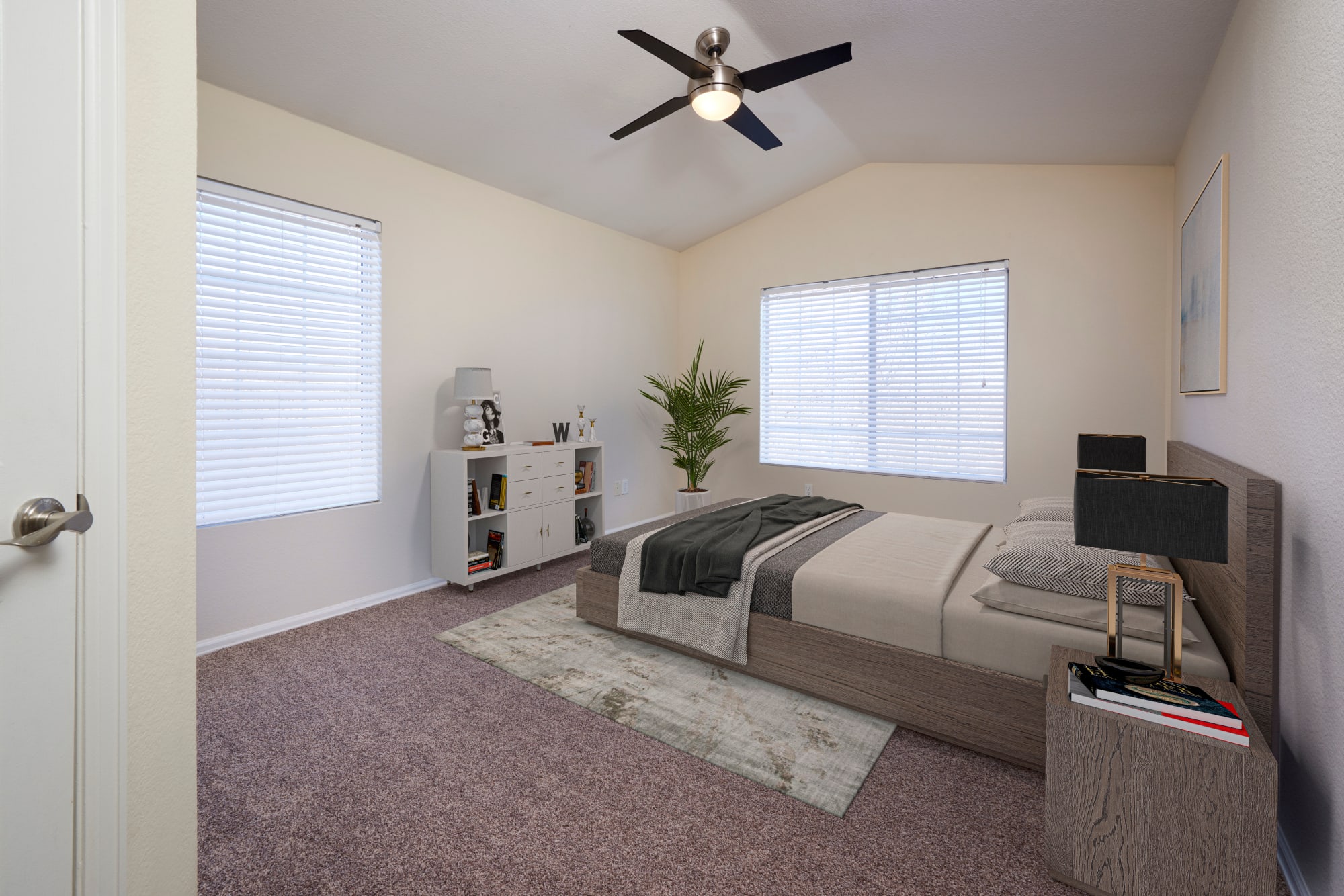 A spacious master bedroom with a bathroom at The Crossings at Bear Creek Apartments in Lakewood, Colorado