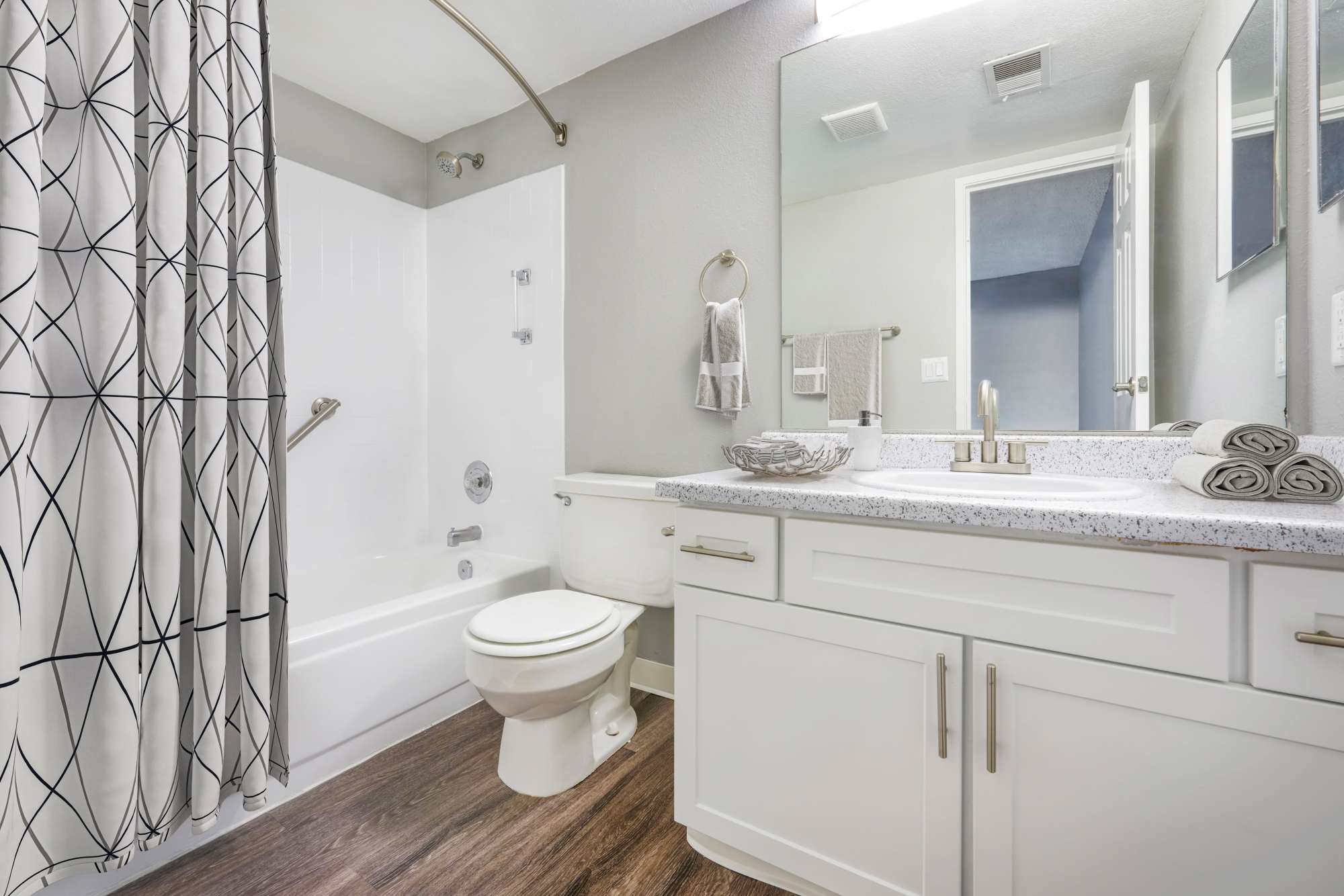 A model bathroom with white cabinets at Alton Green Apartments in Denver, Colorado
