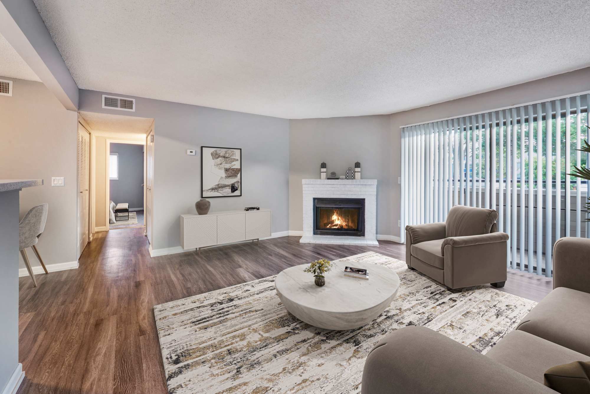 Well decorated living room with a fireplace at Alton Green Apartments in Denver, Colorado