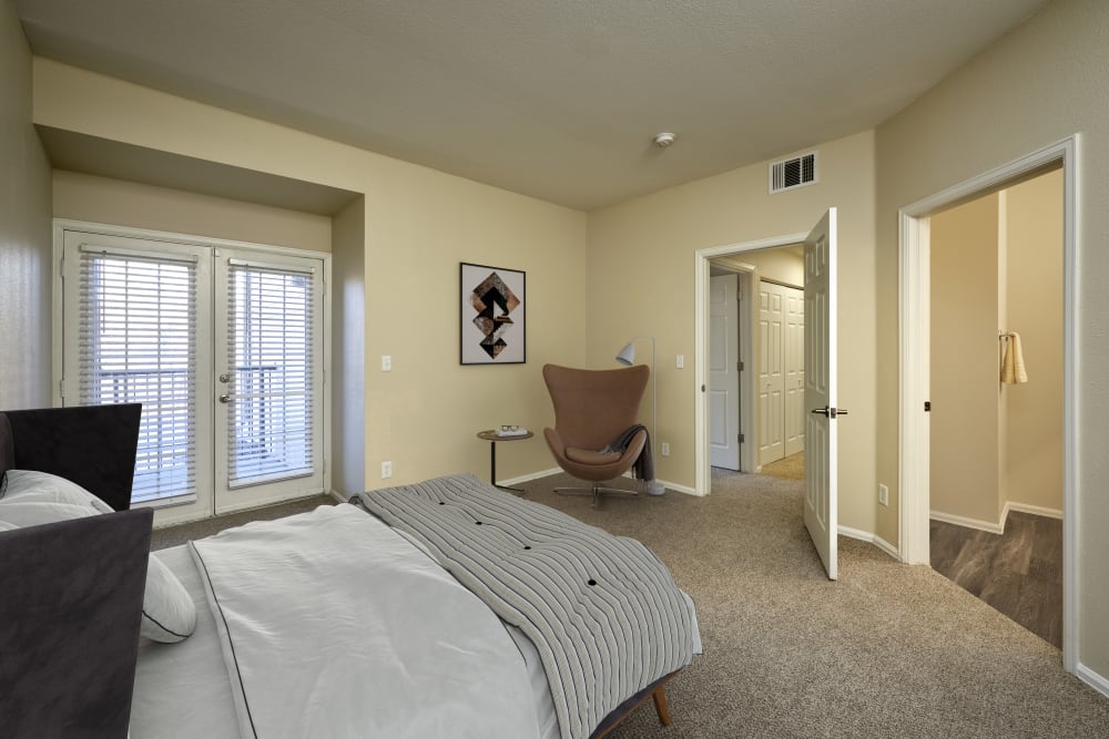 Master bedroom with an attached bathroom at The Crossings at Bear Creek Apartments in Lakewood, Colorado