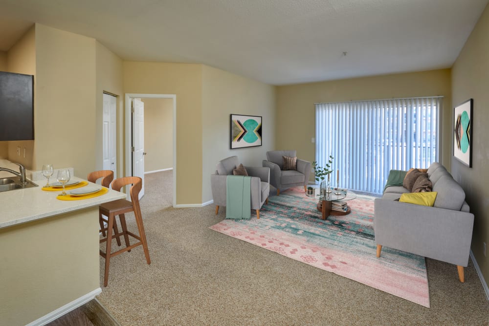 Living room with plush carpeting at The Crossings at Bear Creek Apartments in Lakewood, Colorado