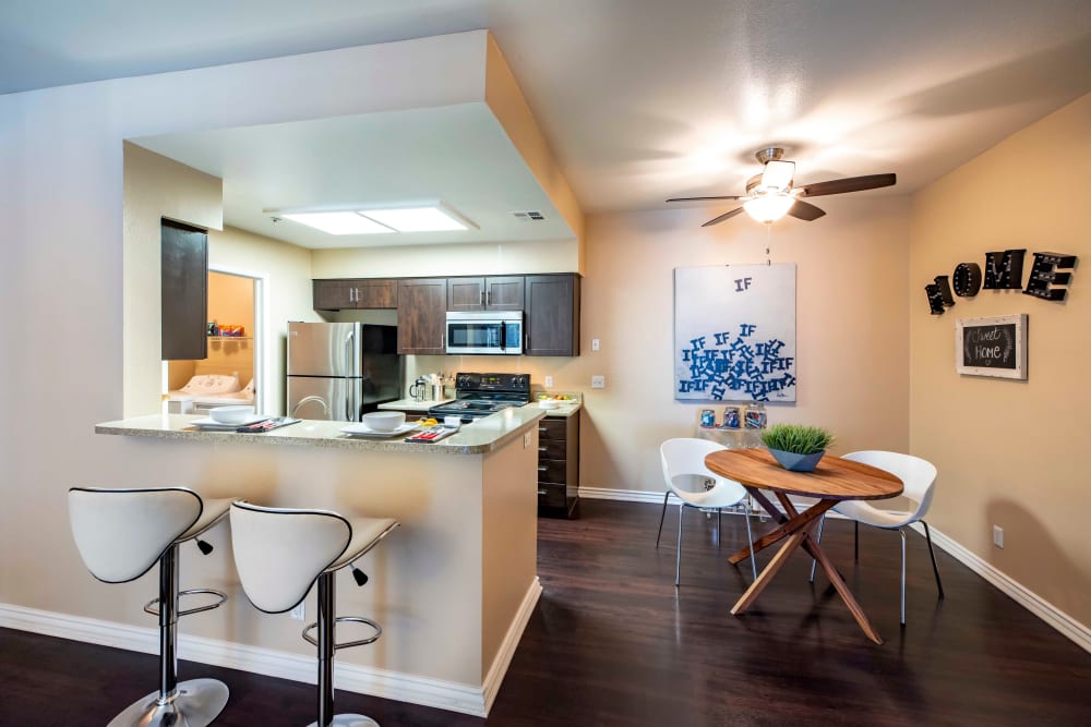 Bar-top seating looking into a kitchen at Sierra Del Oro Apartments in Corona, California