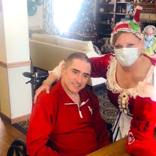 A resident receiving a stocking from a caretaker at Ashbrook Village in Duncan, Oklahoma