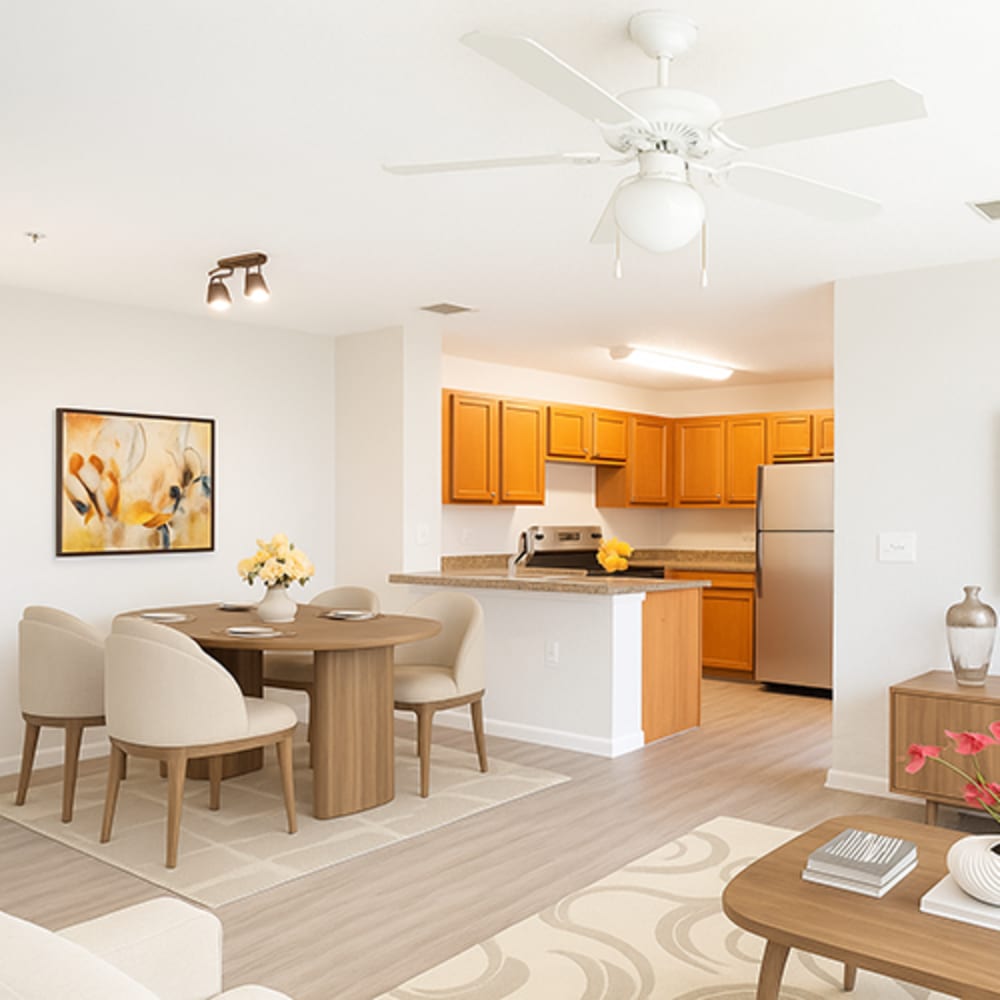 Bright open layout featuring wood-style flooring, modern kitchen with stainless steel appliances and granite countertops, stylish dining area at The Reserve at Brookhaven in Palm Coast, Florida