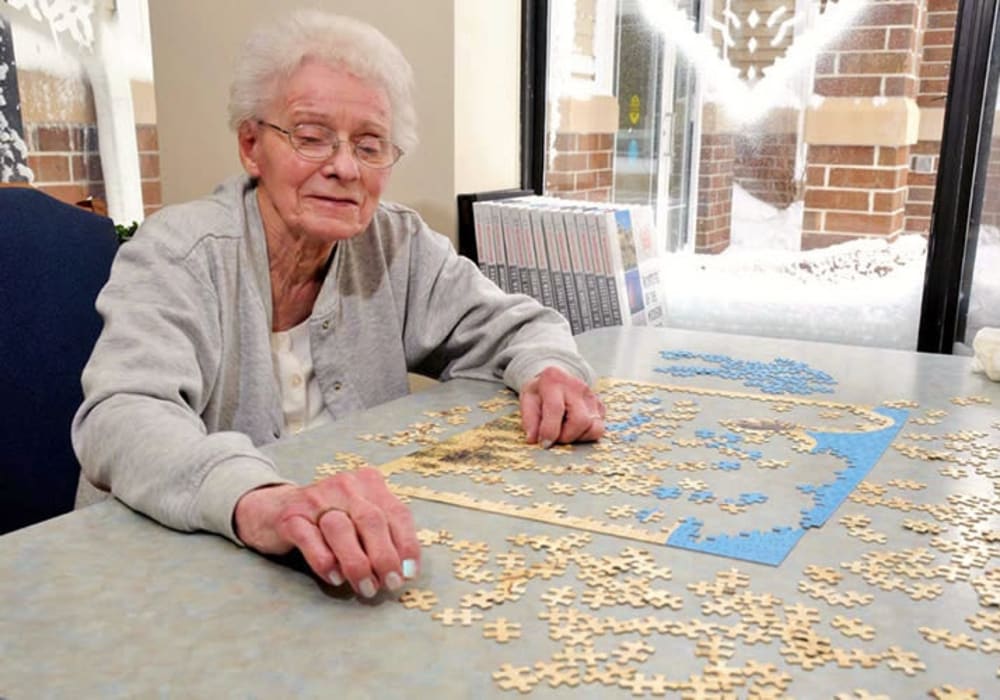 Resident putting together a puzzle at Geneva Lake Manor in Lake Geneva, Wisconsin