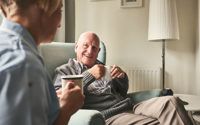 Resident enjoying coffee with a caregiver at Grand Villa of New Port Richey in New Port Richey, Florida