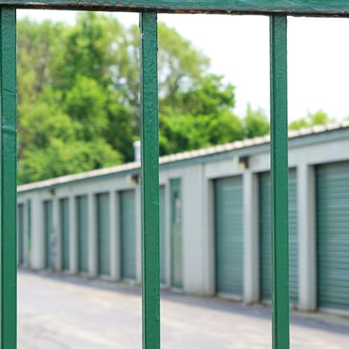 A green security fence in front of climate controlled storage units at Red Dot Storage in Woodstock, Illinois