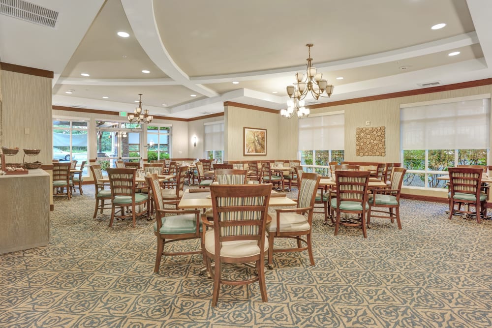 A room filled with tables and chairs with chandeliers hanging above at The Creekside in Woodinville, Washington