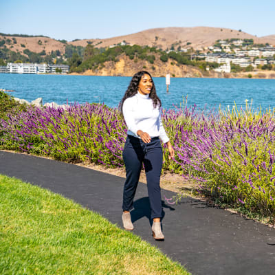 Resident going for a walk on one of the paths along the bay at Harbor Point Apartments in Mill Valley, California