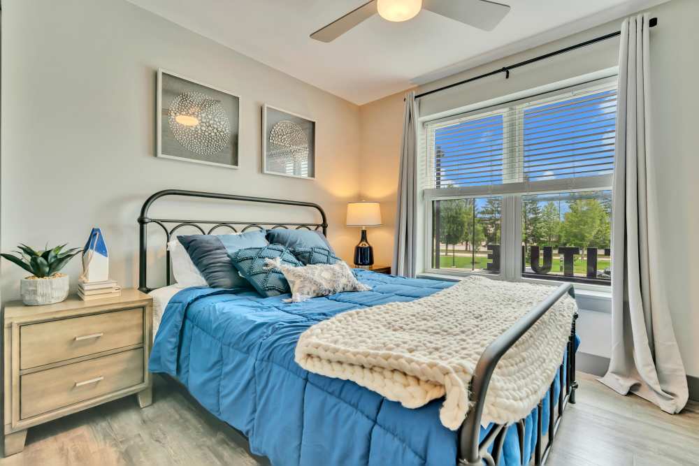 Bed with blue bedding and decorative pillows at Latitude at South Portland in Portland, Maine