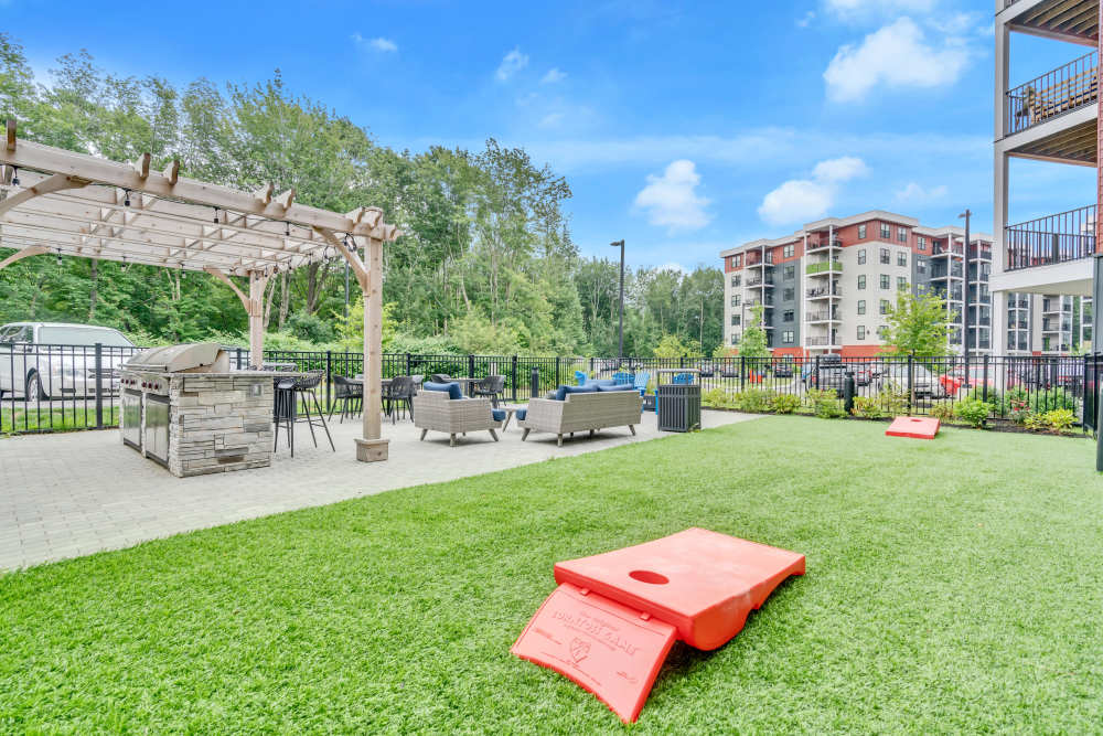 Green grass with red cornhole boards at Latitude at South Portland in Portland, Maine