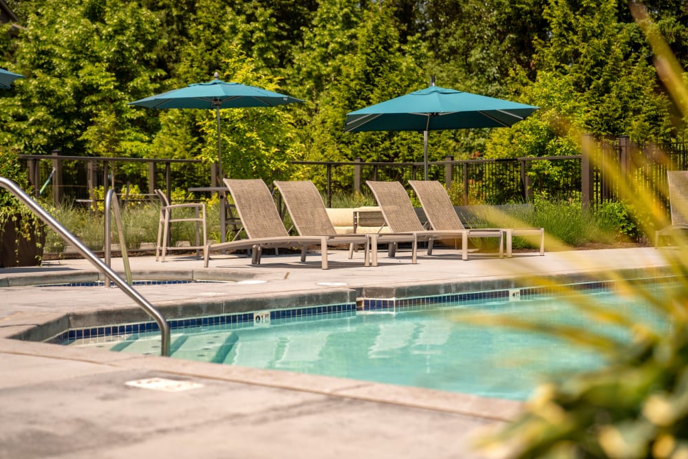 Beautiful resort-style swimming pool with lounge chairs at Brookside Village in Auburn, Washington