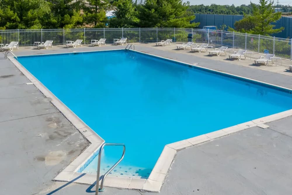 Swimming pool with lounge chairs at Woodspring Apartments in Florence, Kentucky