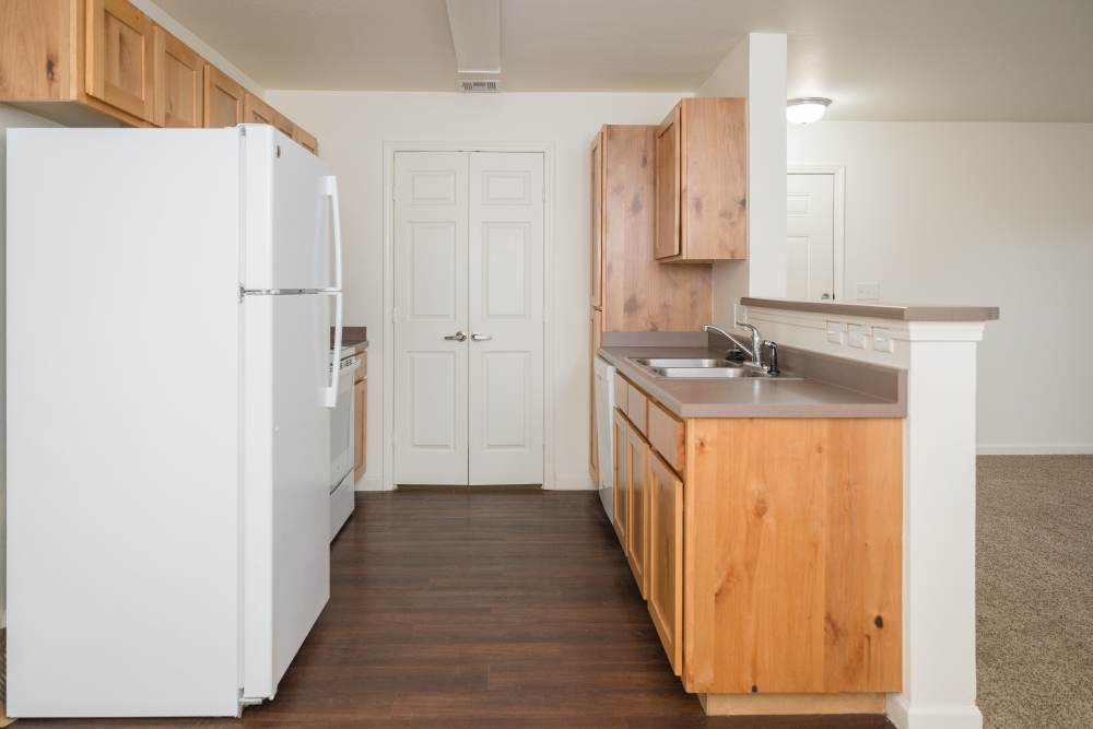 Modern kitchen with sleek appliances and warm wood cabinetry at Cascade Villas in Wichita Falls, Texas.