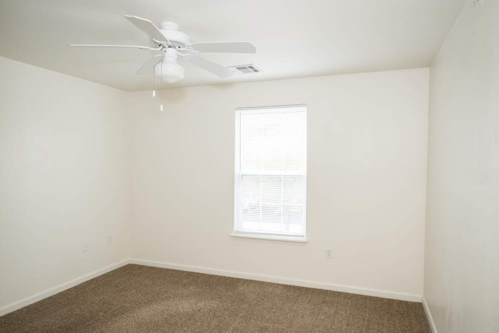 Charming bedroom with natural light and cozy carpet at Cascade Villas in Wichita Falls, Texas.